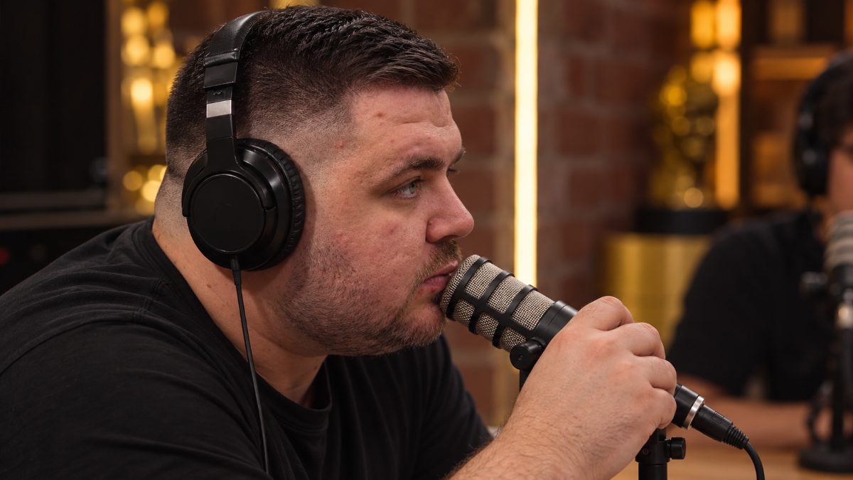 Stiven Janaqi me kufje, duke folur në mikrofon në një studio podkasti